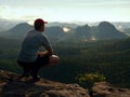 Hiker man take a rest on mountain peak. Man sit on summit, Royalty Free Stock Photo