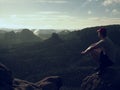 Hiker man take a rest on mountain peak. Man sit on summit,