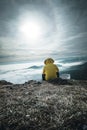 Hiker man take a rest on mountain peak. Man sit on sharp summit and enjoy spectacular view Royalty Free Stock Photo