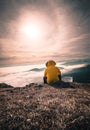 Hiker man take a rest on mountain peak. Man sit on sharp summit and enjoy spectacular view Royalty Free Stock Photo