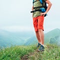 Hiker man walking by the cloudy and foggy weather mountain range path with backpack. Active sport backpacking healthy lifestyle Royalty Free Stock Photo