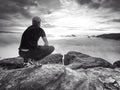 Hiker in middle of nowhere and thinking alone. Man sit on top