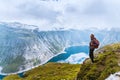 Young woman with backpack standing on fjord coast