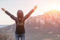 Hiker in mountains with arms raised in air. view from back Royalty Free Stock Photo