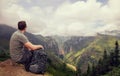 Hiker in mountains relaxing on top of a rock and enjoying view m Royalty Free Stock Photo