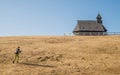 Hiker near raditional wooden church on Velika Planina