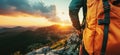 Hiker with orange backpack enjoying sunset view over mountain landscape Royalty Free Stock Photo