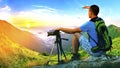 Hiker photographer sitting on a rock looking forward on sunrise Royalty Free Stock Photo