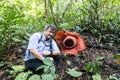 Hiker posing with Rafflesia, the largest flower in the world