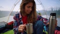 Hiker pouring tea in cup during camping in mountains. Woman drinking coffee Royalty Free Stock Photo