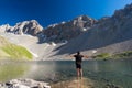 Hiker relaxing at high altitude blue lake in idyllic uncontaminated environment once covered by glaciers. Summer adventures and ex