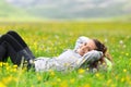 Hiker resting lying on the grass looks at you