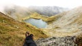 Hiker resting on mountain top with feet in view Royalty Free Stock Photo