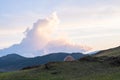 A hiker\'s tent on a green field overlooking beautiful mountain landscape. Tent on the mountain on the background Royalty Free Stock Photo