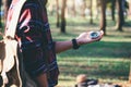 Hiker searching direction with a compass in the forest