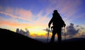 Hiker silhouette on mountain peak looking at sunset