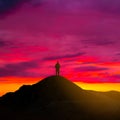 Hiker silhouette stay on mount top at the dramatic sunset