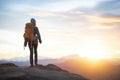 hiker silhouetted against a sunset on a mountaintop