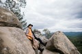 A hiker sits in the mountains on a rock and rests after a difficult climb Royalty Free Stock Photo