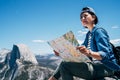 Hiker sitting holding paper map finding direction