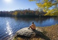 Man relaxing by the beautiful lake on the autumn morning..