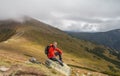 Hiker sitting on rock builder in mountains Royalty Free Stock Photo