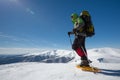 Hiker snowshoeing in winter mountains during sunny day Royalty Free Stock Photo