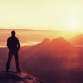 Hiker stand on the sharp corner of sandstone rock in rock empires park and watching over the misty and foggy morning valley to Sun Royalty Free Stock Photo