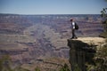 Hiker standing on edge of cliff at Grand Canyon