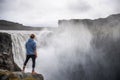 Hiker standing at the edge of the Dettifoss waterfall in Iceland