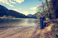 Hiker standing on the lake among the mountains