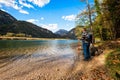 Hiker standing on the lake among the mountains