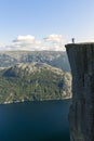 Hiker standing on Preikestolen and looking on the fjerd, Preikestolen - famous cliff at the Norwegian mountains, Norway Royalty Free Stock Photo