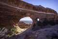 Hiker standing under Partition Arch in Arches National Park