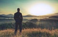 Hiker stands and enjoys valley view from hill