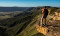 HIker Stands On Rock Shelf Looking Over Mesa Verde