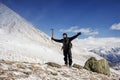 Hiker stays on a snow mountain hill and enjoy beautiful view.
