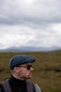 Hiker with sunglasses and baret in the Scottish Highlands.