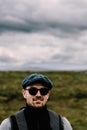 Hiker with sunglasses and baret in the Scottish Highlands.