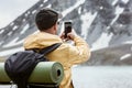 Hiker takes mobile photo of mountain lake