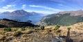 A hiker taking a photo as shown by his shadow while at a lookout over the gorgeous town of Queenstown and Lake Wakatipu