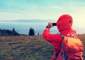 Hiker taking photo with smart phone at mountain peak Royalty Free Stock Photo