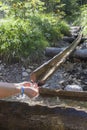 Hiker taking water from mountain stream Royalty Free Stock Photo