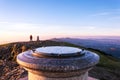 A hiker at the toposcope at the top of Worcestershire Beacon, on a misty, sunrise on a winters morning. Malvern Hills, UK