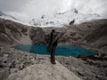 Hiker in traditional indigenous poncho cape at andean mountain lake Laguna 69 Cordillera Blanca Huaraz Ancash Peru