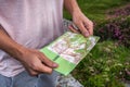 Hiker traveler tourist holds map of mountains summer