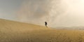 Hiker Trudging through desert sand dunes in Death Valley National Park