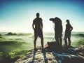 Hiker with two photographers on summit watch sunrise at horizon Royalty Free Stock Photo