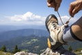 Hiker tying boot laces, high in the mountains Royalty Free Stock Photo