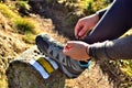 Hiker tying her trekking shoes on a hiking stone marking the tourist route Royalty Free Stock Photo